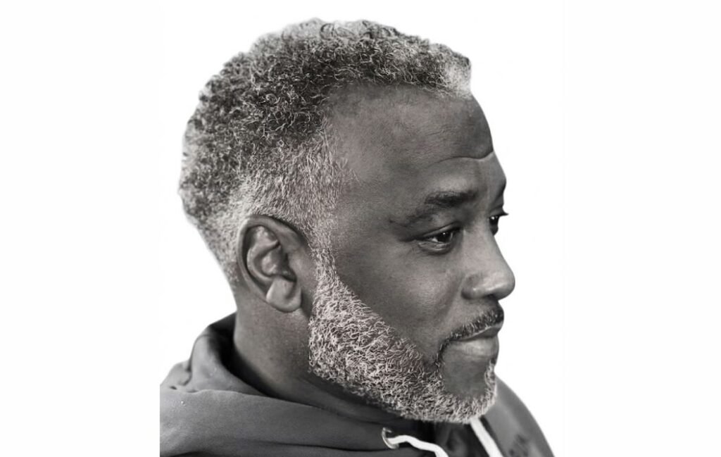 An old black man with short afro taper haircut