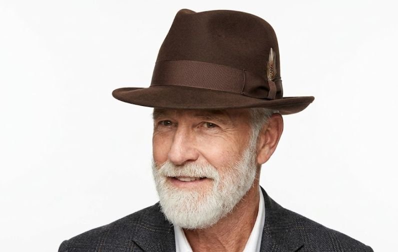 An older man wearing a hat as one of the wardrobe essentials for older men