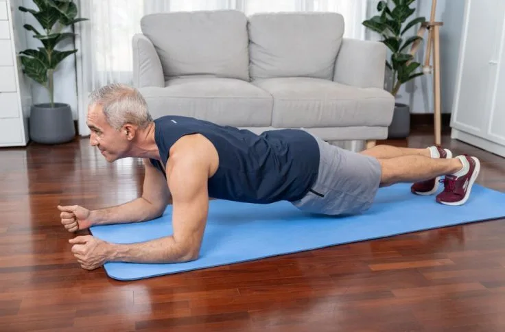 A man over 50 doing planks for core strength