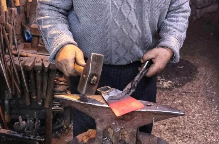 A man engaging in crafty hobbies of blacksmithing 