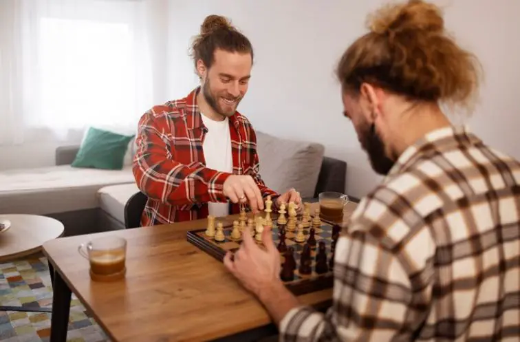 Two men playing chess at home for hobby