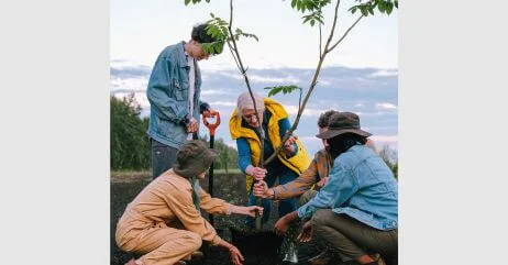 Group of people planting a tree to help the environment to show environmental chivalry