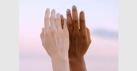 A white and black hand in depiction of equity to demonstrate modern chivalry