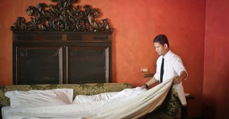 A gentleman's personal attendant making the bed of the master