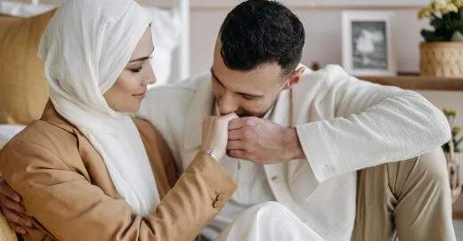 A man kissing the hand of a woman