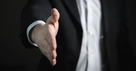A demonstration of hand position in preparation to shake a hand