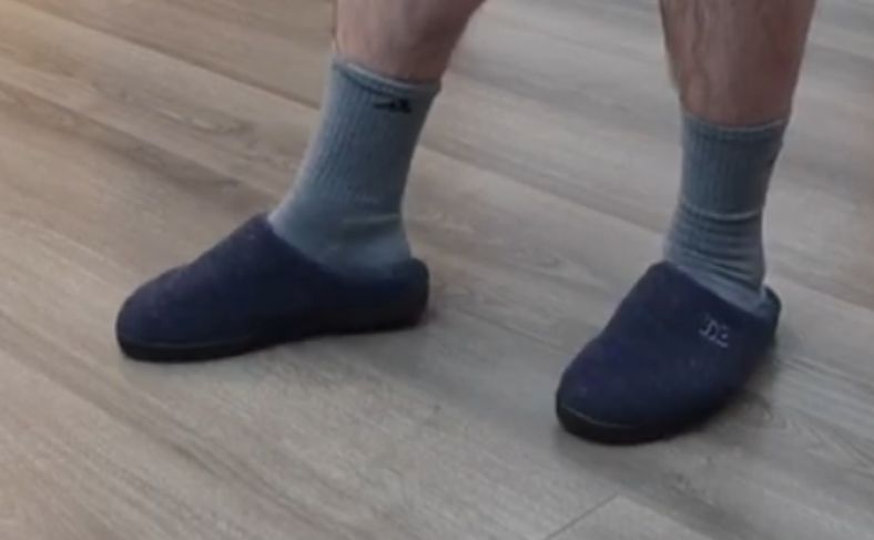 A man wearing the Men's Memory Foam Slippers for Seniors