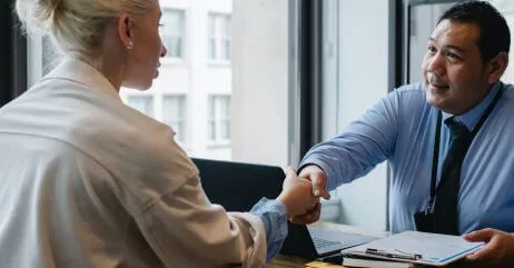A man and woman observing professional handshake
