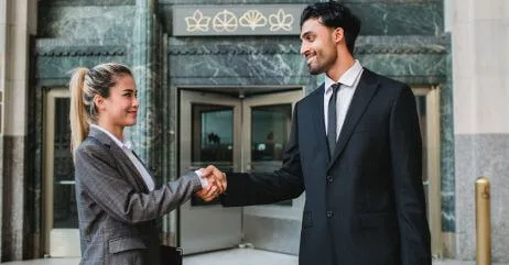 A woman and man demonstrating woman handshake etiquette